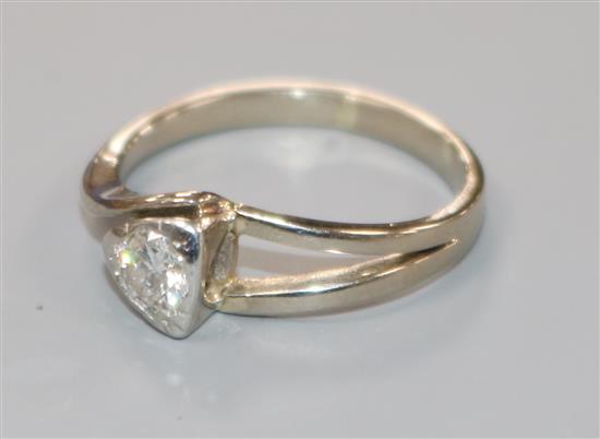 An 18ct white gold and collet set solitaire diamond ring, size L.